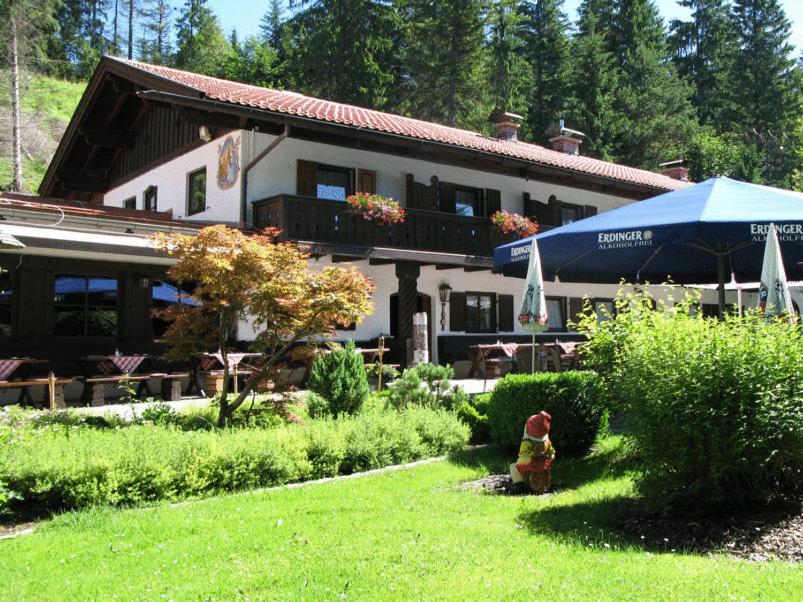 un edificio con patio y un patio con sombrilla en Landgasthof Sonnenhof, en Klais