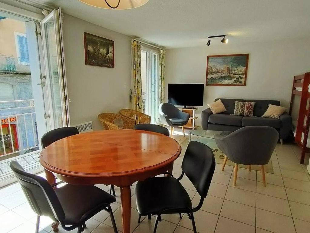 ein Wohnzimmer mit einem Holztisch und Stühlen in der Unterkunft Appartement Cauterets, 3 pièces, 8 personnes - FR-1-234-78 in Cauterets