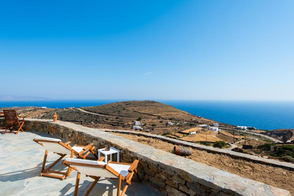 a person sitting in a chair on top of a wall at Tholos Guest House in Sifnos