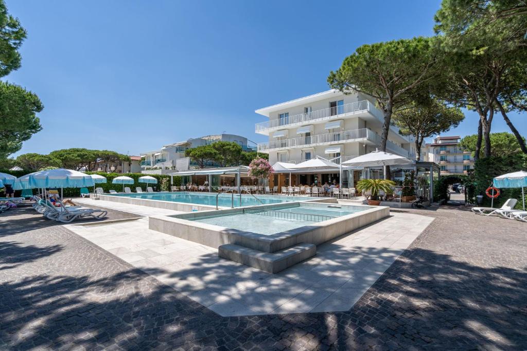 a swimming pool with a fountain in front of a building at Hotel Bauer & Sporting in Lido di Jesolo