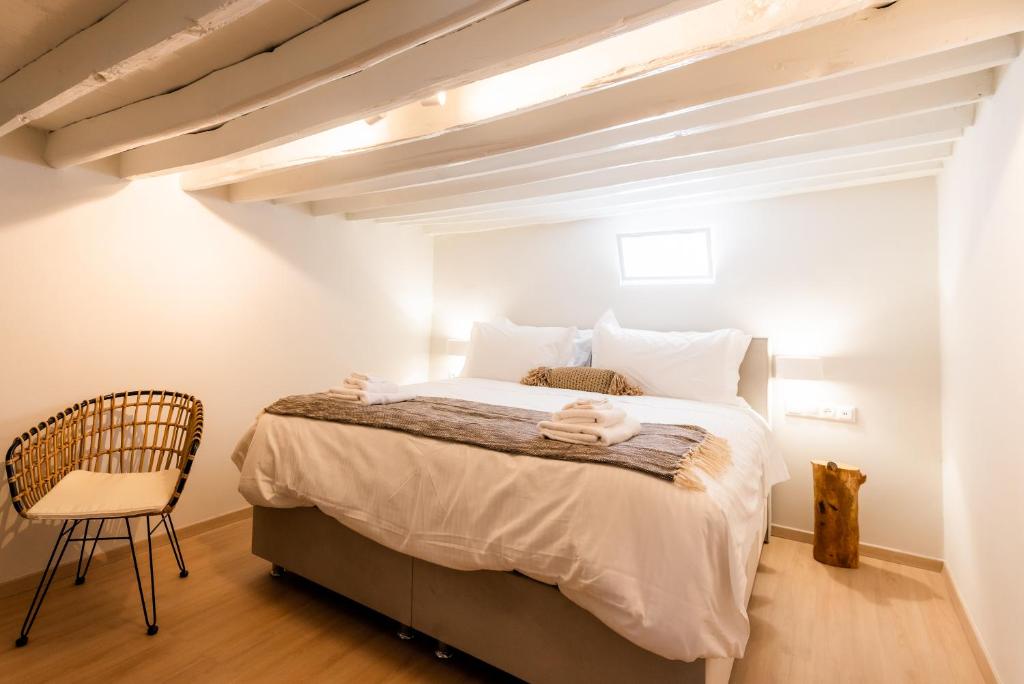Guru accommodations في مدينة ميكونوس: غرفة نوم فيها سرير وكرسي
