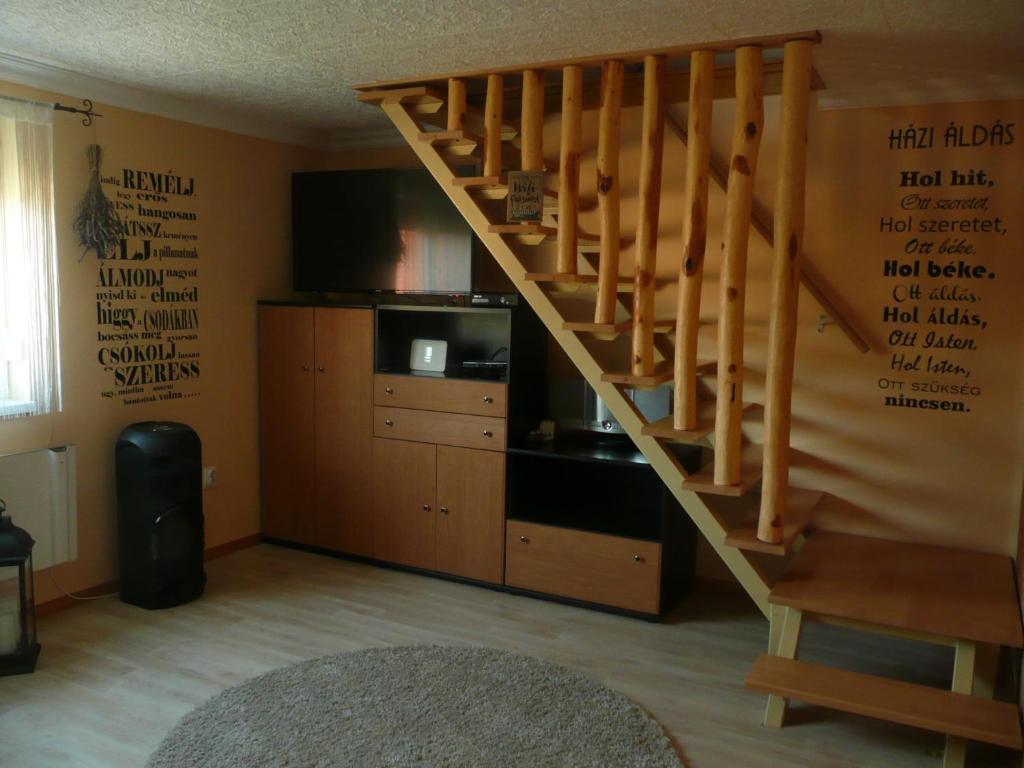 ハイドゥーナーナーシュにあるLevendula Vendégházのリビングルーム(木製の階段、テレビ付)