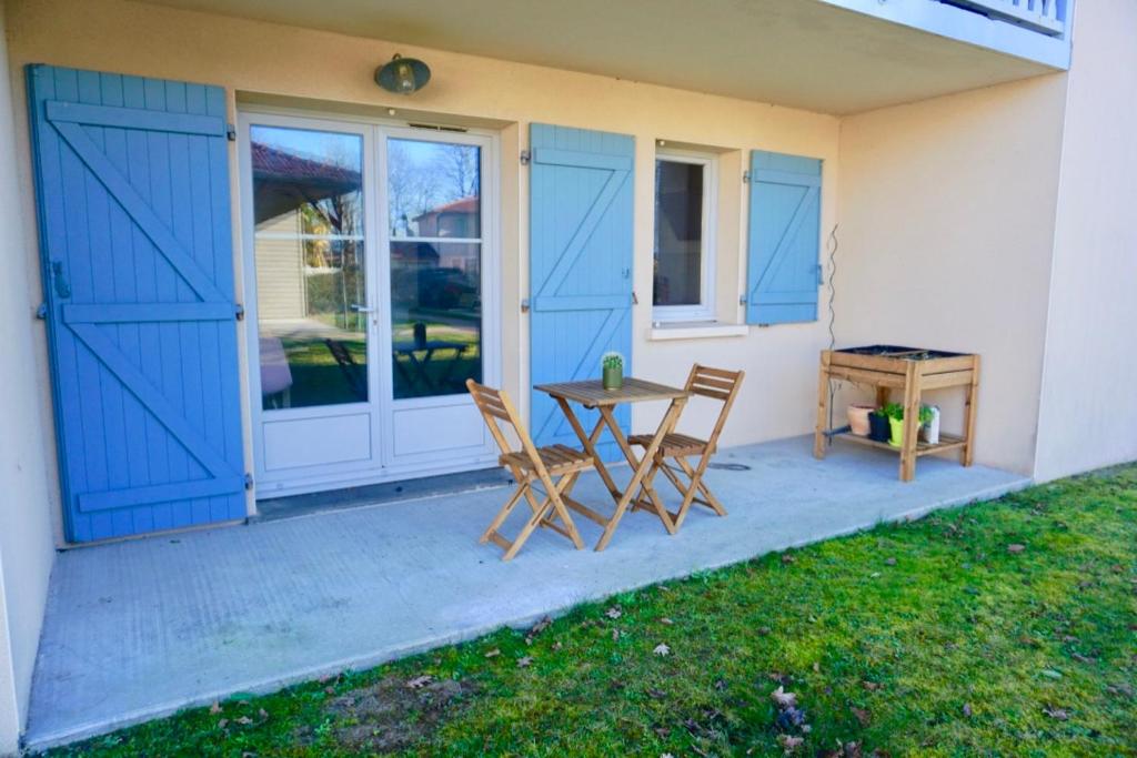 a patio with two chairs and a table in front of a house at Superbe appartement avec piscine in Aureilhan