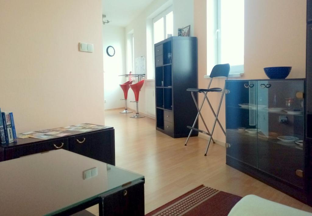 ein Wohnzimmer mit einem schwarzen Schrank und einem Tisch in der Unterkunft Apartment ODEON in Most