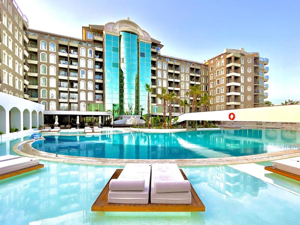 una piscina con due sedie a sdraio di fronte ad alcuni edifici di LAUR HOTELS Experience & Elegance a Didim