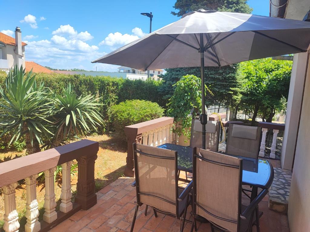 d'une table et de chaises sous un parasol sur le balcon. dans l'établissement Deni09, à Pomer