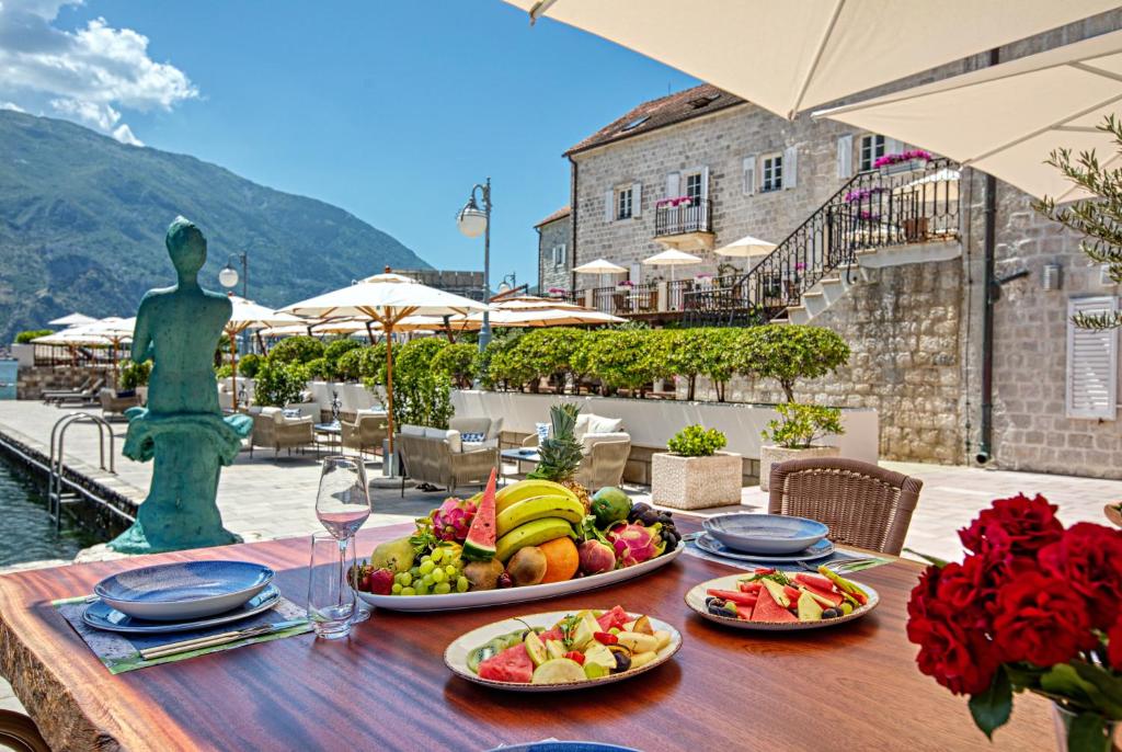 a table with plates of food on top of a table at Hotel Splendido in Kotor