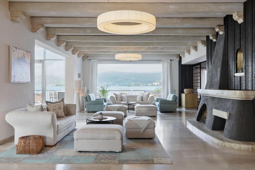 a living room with couches and a fireplace at Hotel Linde in Maria Wörth