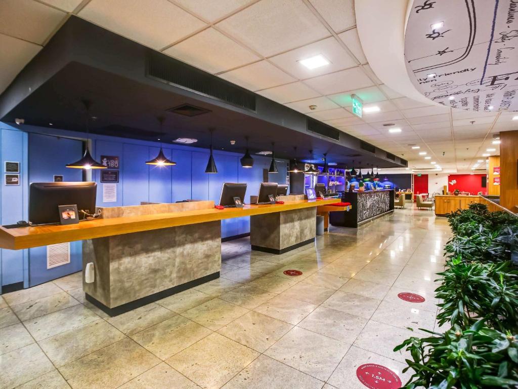 a lobby with blue walls and a long counter at ibis Rio de Janeiro Nova America in Rio de Janeiro