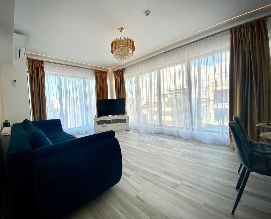 a living room with a couch and a tv and windows at Bel Air Mamaia Nord Complex - Apartament Delux in Mamaia