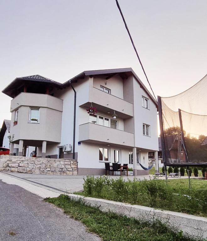 a large white building on the side of a street at Apartmani Bilić in Korenica