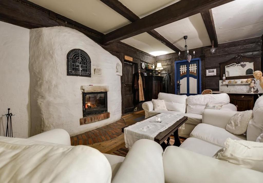 a living room with white couches and a fireplace at "U LAWENDOWEJ WIEDŹMY" - stylowa agroturystyka z klimatem in Istebna