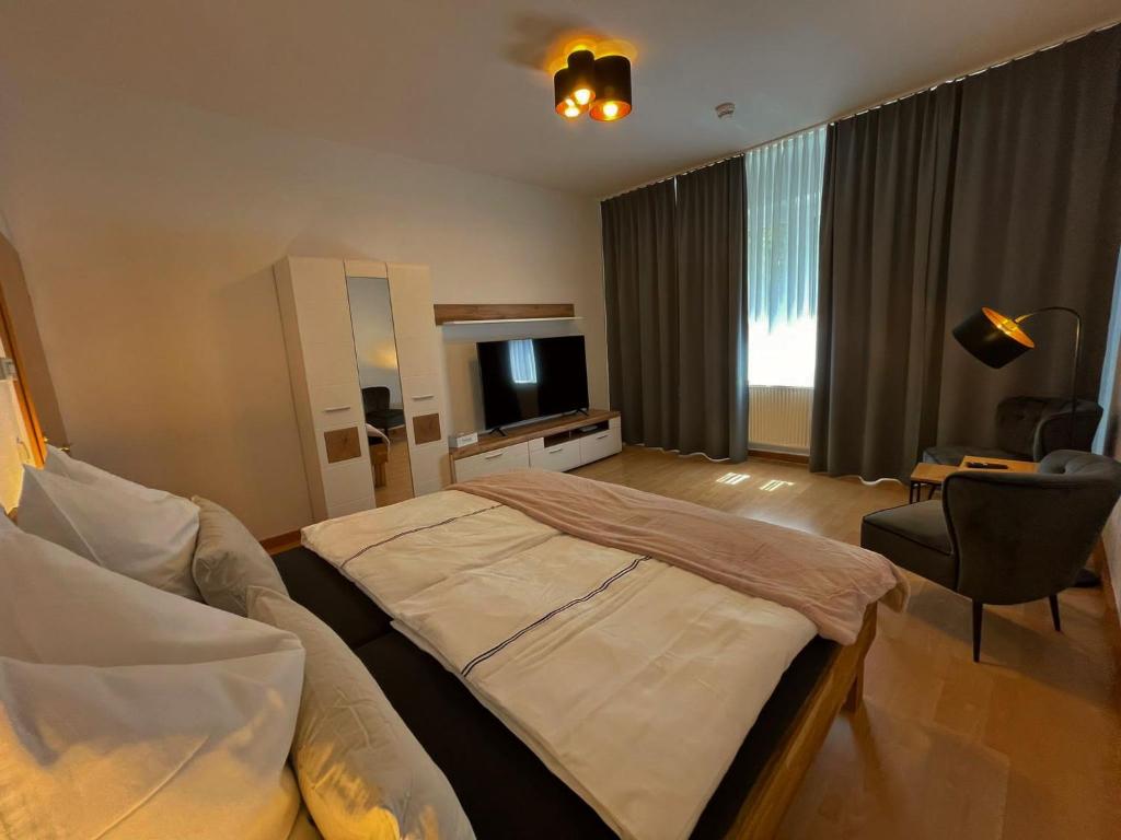 um quarto com uma cama grande e uma televisão em Jade FeWo Cottbus em Cottbus