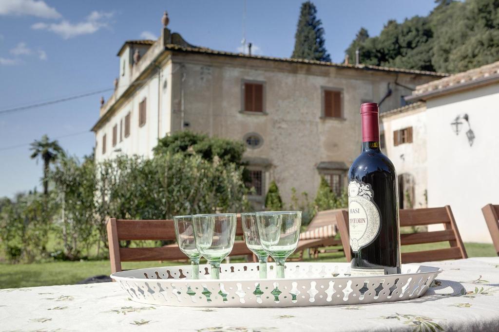 una botella de vino sentada en una mesa con copas en Fattoria di Macia, en Calenzano