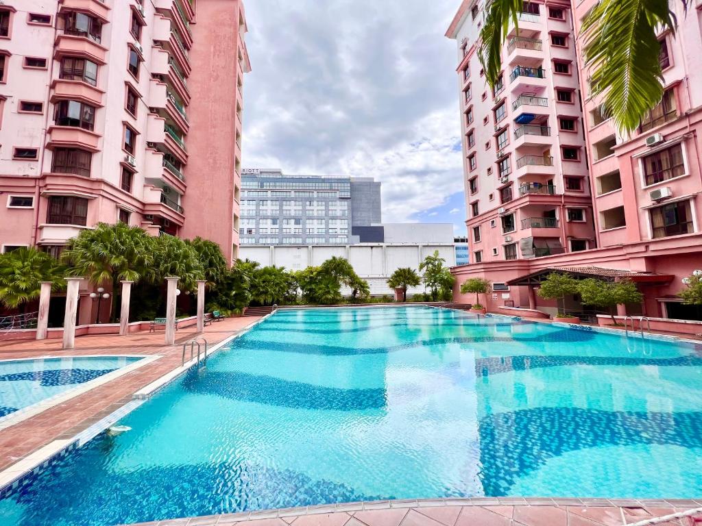 a large swimming pool between two tall buildings at MARINA COURT VACATION HOME 3 BEDROOMS - Kota Kinabalu in Kota Kinabalu