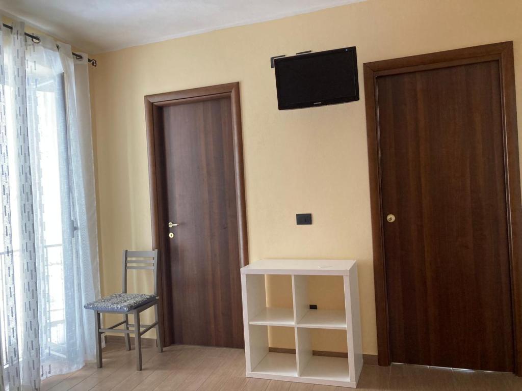 um quarto com uma porta e uma televisão na parede em Casa di Vigata em Licata