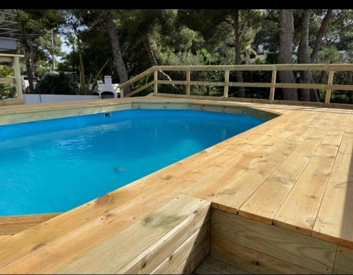 a swimming pool with a wooden deck next to a wooden pool at Vele del Pizzo - piscina in Gallipoli