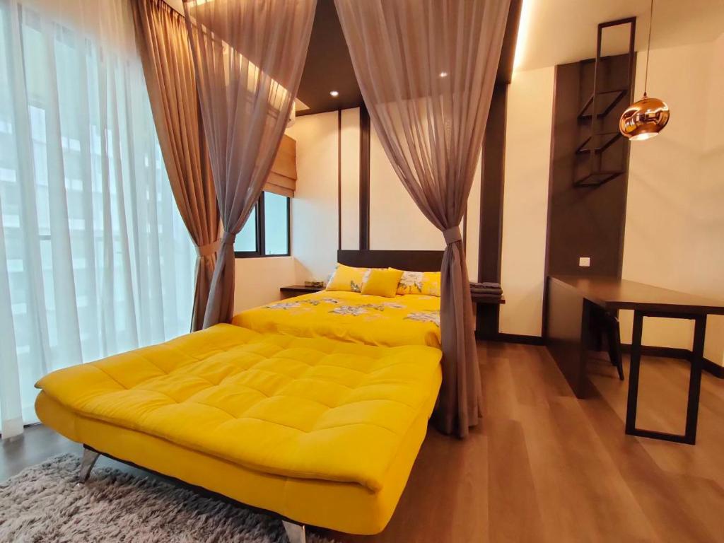 ein Schlafzimmer mit einem gelben Bett und einem Schreibtisch in der Unterkunft CASA SAKURA Studio Vista Bangi with Wi-fi & Netflix in Kajang