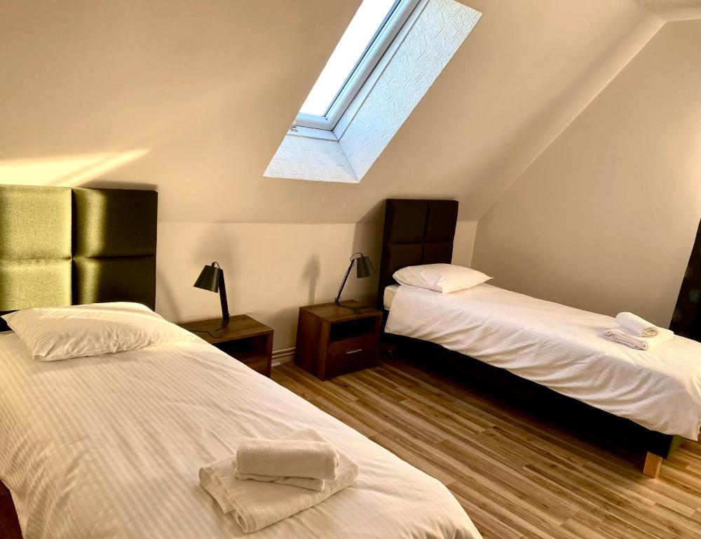 a attic bedroom with two beds and a skylight at Apartament Lux in Gołdap