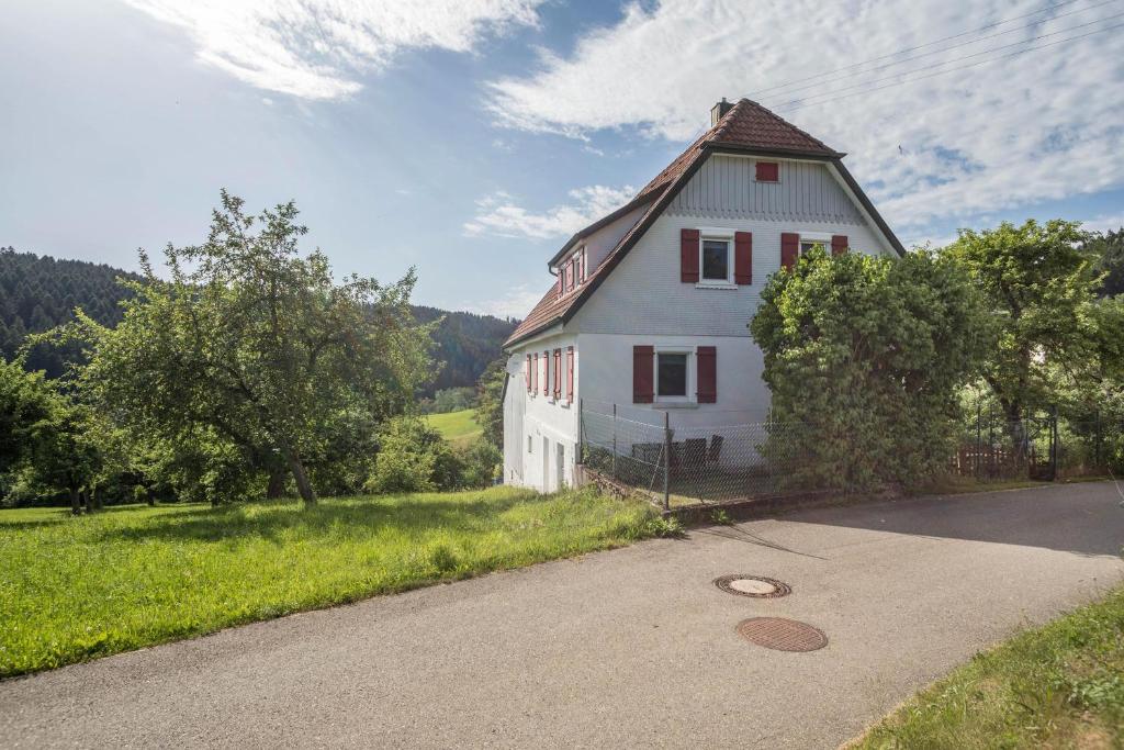 una casa blanca con techo de gambrel en una carretera en Ferienwohnung Schwarzwald Idyll en Glatten
