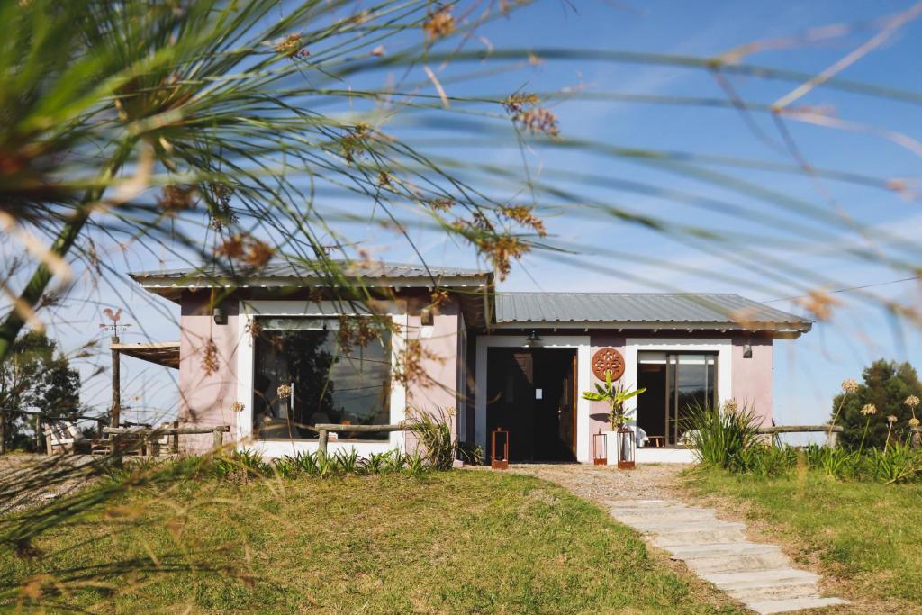 a small pink house with a pathway at Finca Soñada in Colonia del Sacramento