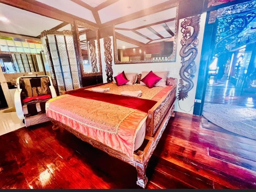 um quarto com uma cama grande e almofadas vermelhas em Crystal Sea Villa em Ko Larn