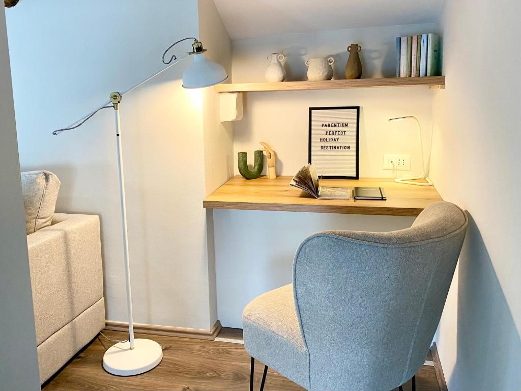 Una habitación con un escritorio con una silla y una lámpara. en PARENTIUM LOFT CENTER SQUARE, en Poreč
