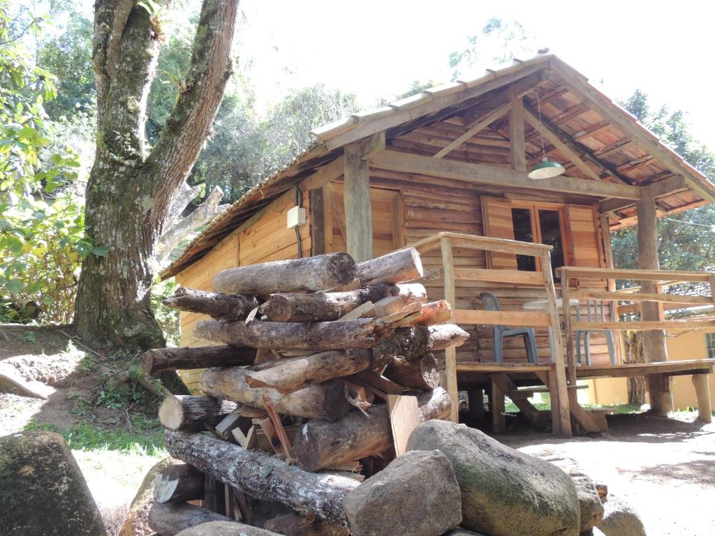 un mucchio di tronchi davanti a una baita di tronchi di Paiol - Tô na Roça - Junto á natureza!!! a Cunha