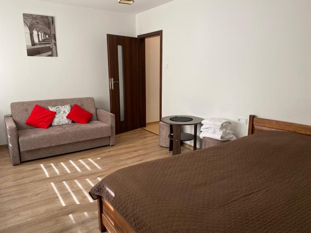 een slaapkamer met een bed, een bank en een tafel bij M&M apartamenty 2 in Zamość