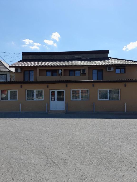 a large yellow building with a lot of windows at Pensiunea Albert in Hîrşova