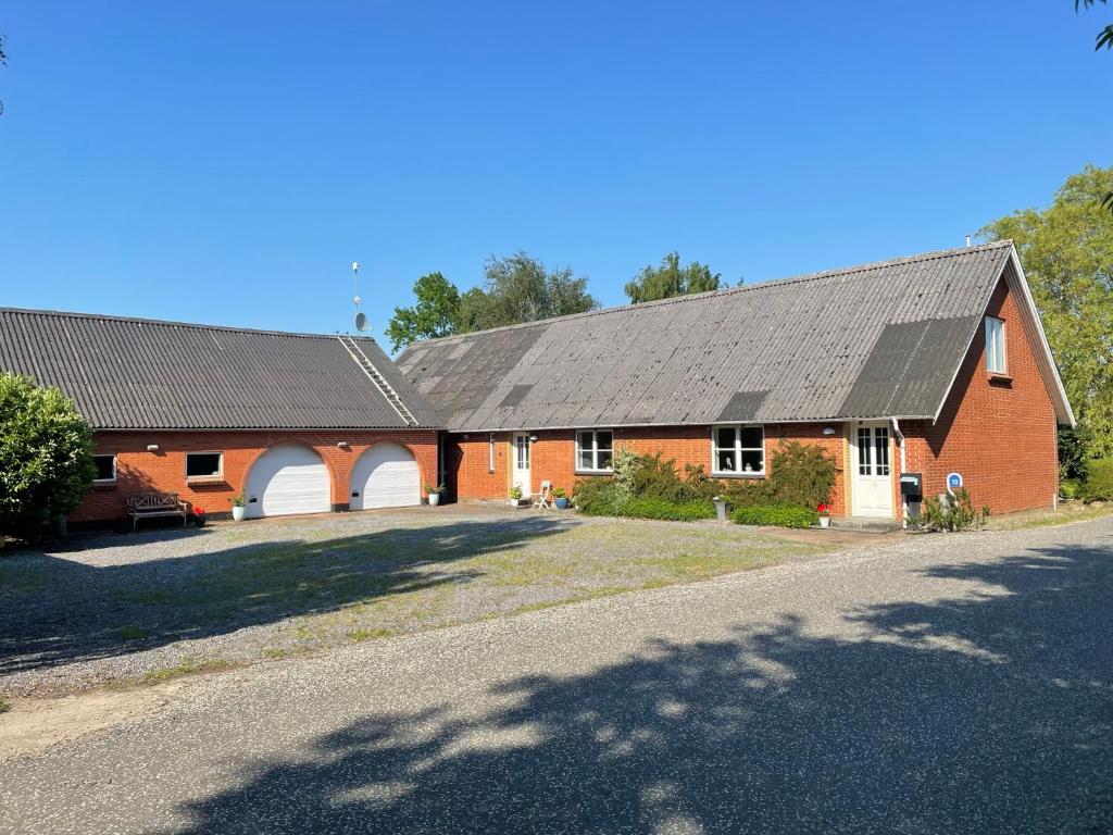 un edificio in mattoni rossi con tetto nero di Kragh B&B a Løsning