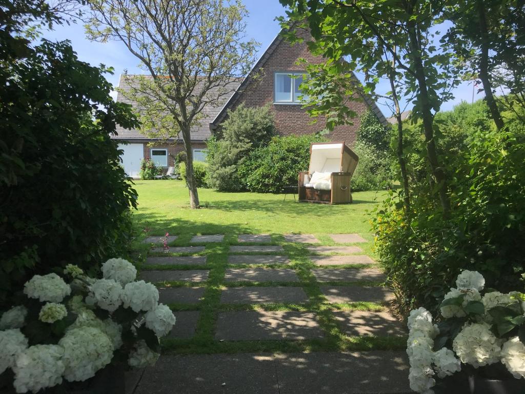 ヴェニングシュテットにあるEremitage Syltの庭にベンチ付きの庭のある家