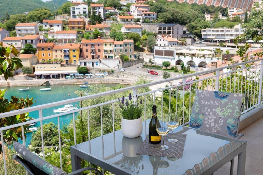 a balcony with a table and a bottle of wine at Allegro in Rabac