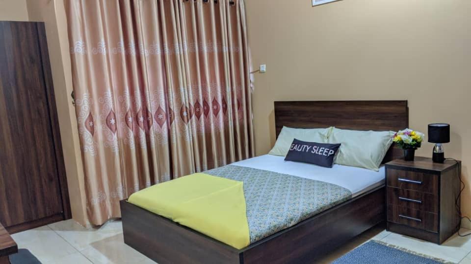a bedroom with a bed with a wooden headboard at majestic cottage in Ayaso