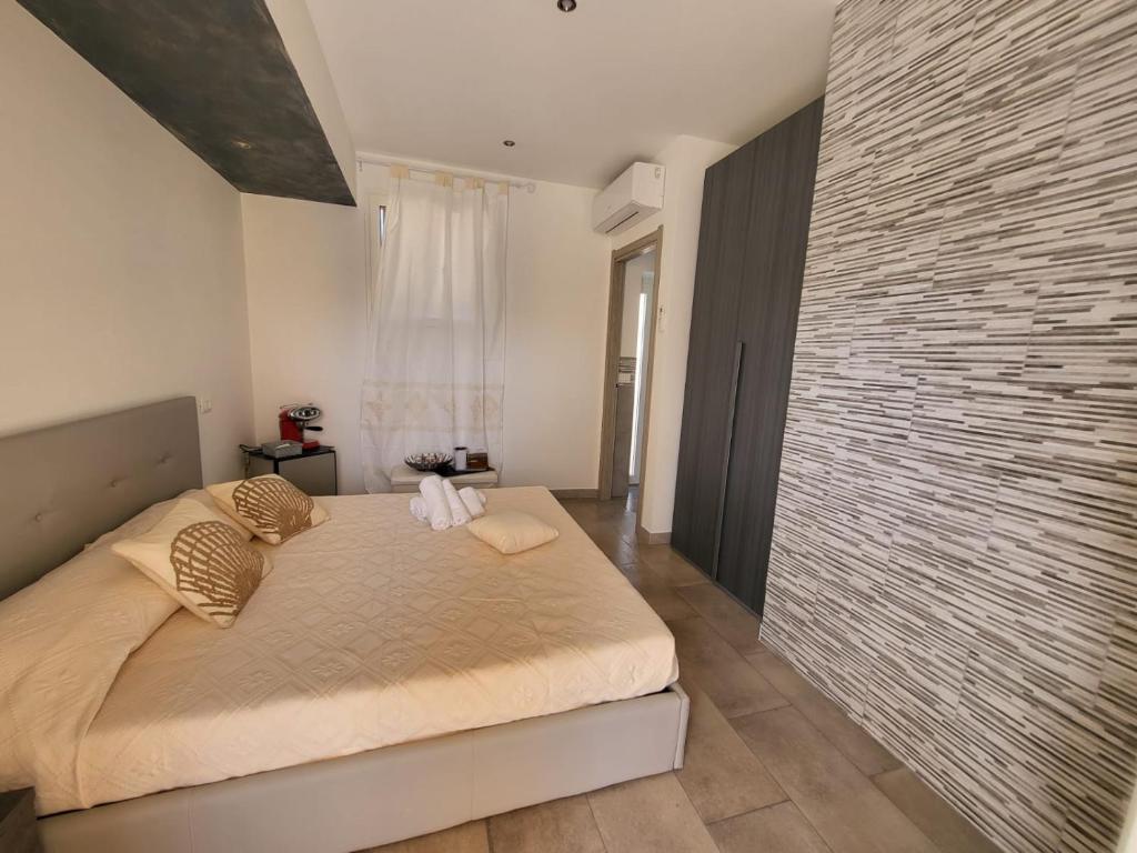 - une chambre avec un lit et un grand mur en briques dans l'établissement Casa Giagoni, à Santa Teresa Gallura