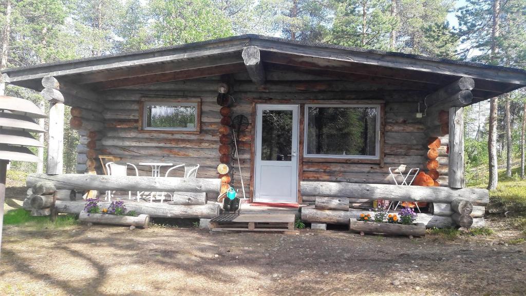 Cabaña de madera con porche y puerta en Cabin at Huskies Farm en Inari