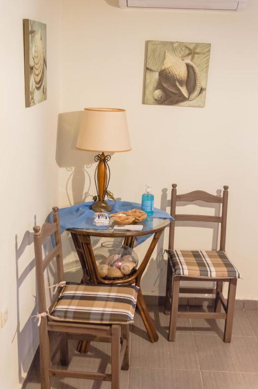 a blue table with a lamp and two chairs at Blue Horizon Dream in Thymonia Beach