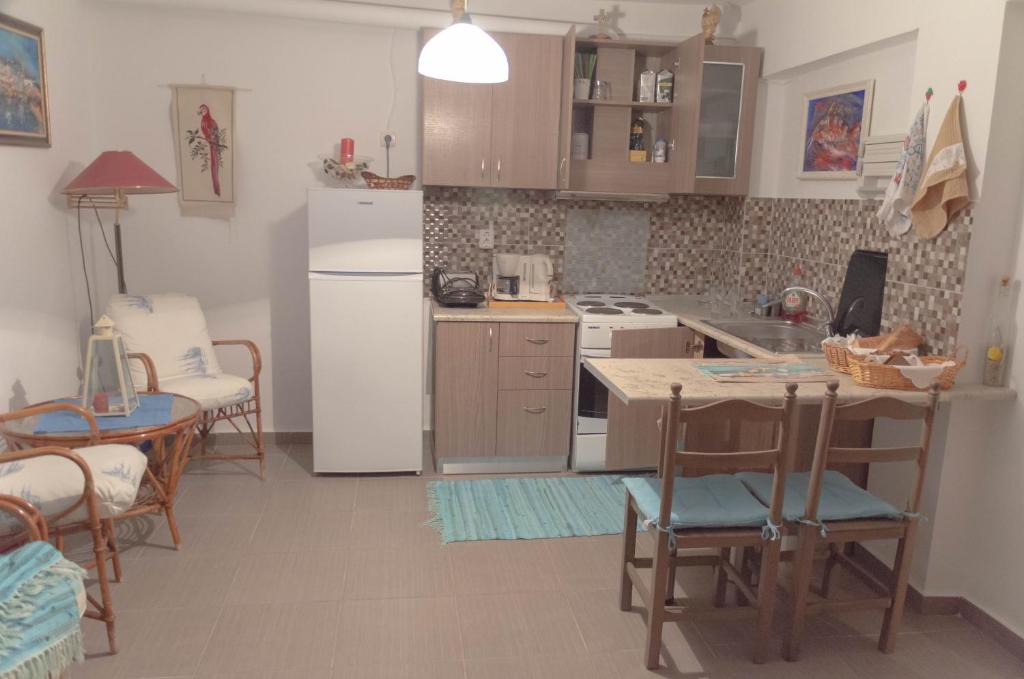 a kitchen with a white refrigerator and a table and chairs at Blue Horizon Dream in Thymonia Beach
