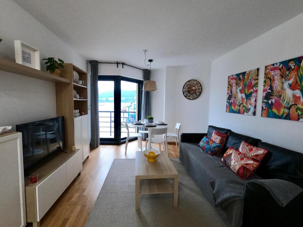 sala de estar con sofá y mesa en Apartamento con balcón y vistas al mar en Viveiro