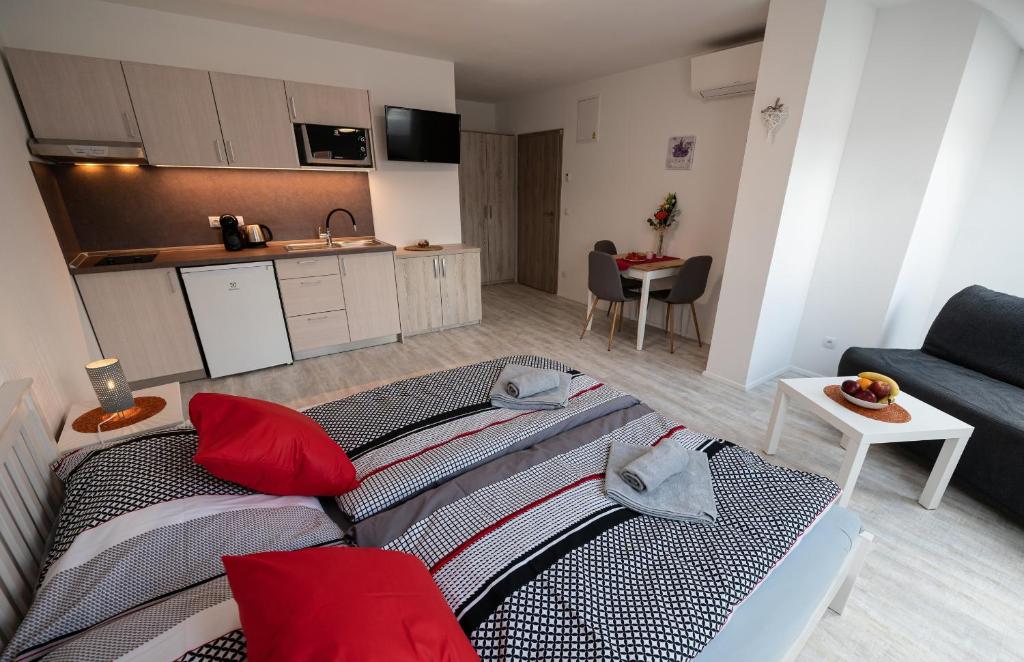 ein Wohnzimmer mit einem Sofa und einer Küche in der Unterkunft Penzion Kamenný dvůr in Třeboň