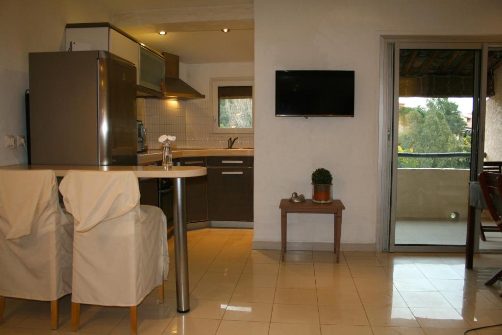 Il comprend une cuisine avec une table et une télévision murale. dans l'établissement Coquet appartement dans mazet Ste Maxime Riviera, à Sainte-Maxime