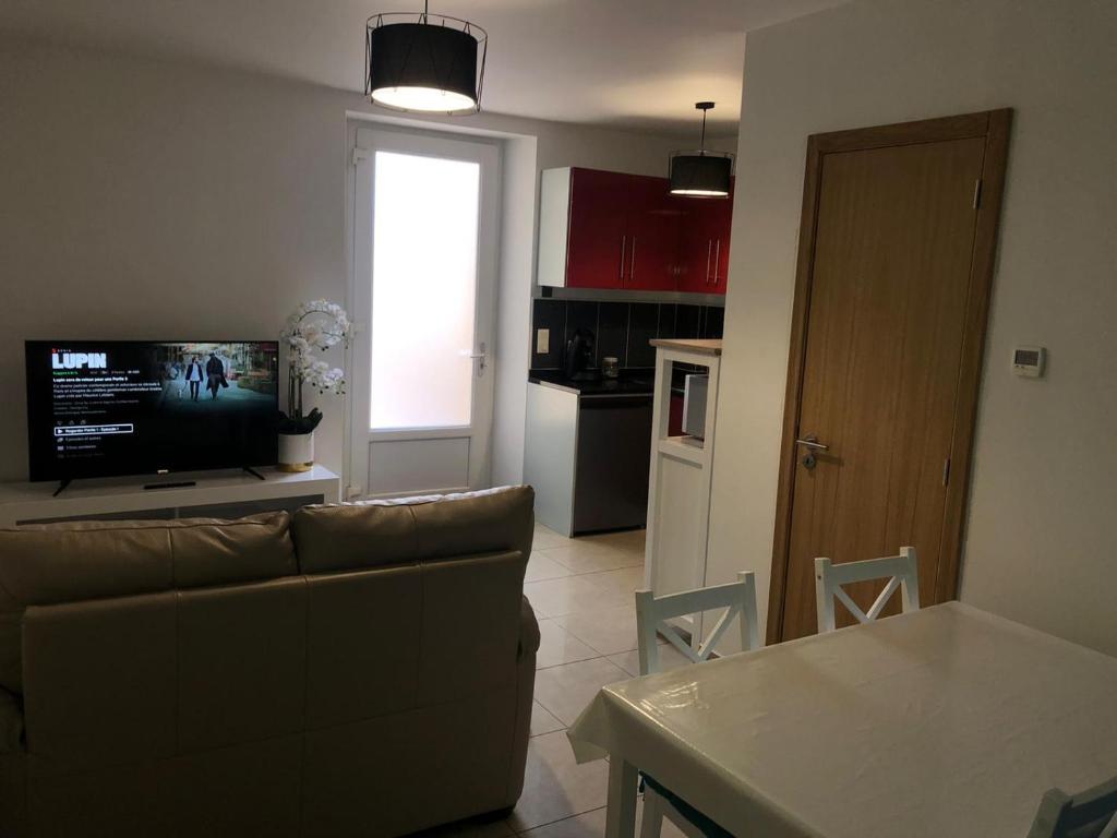 マント・ラ・ジョリーにあるApparemment 003のソファとテレビのあるリビングルーム