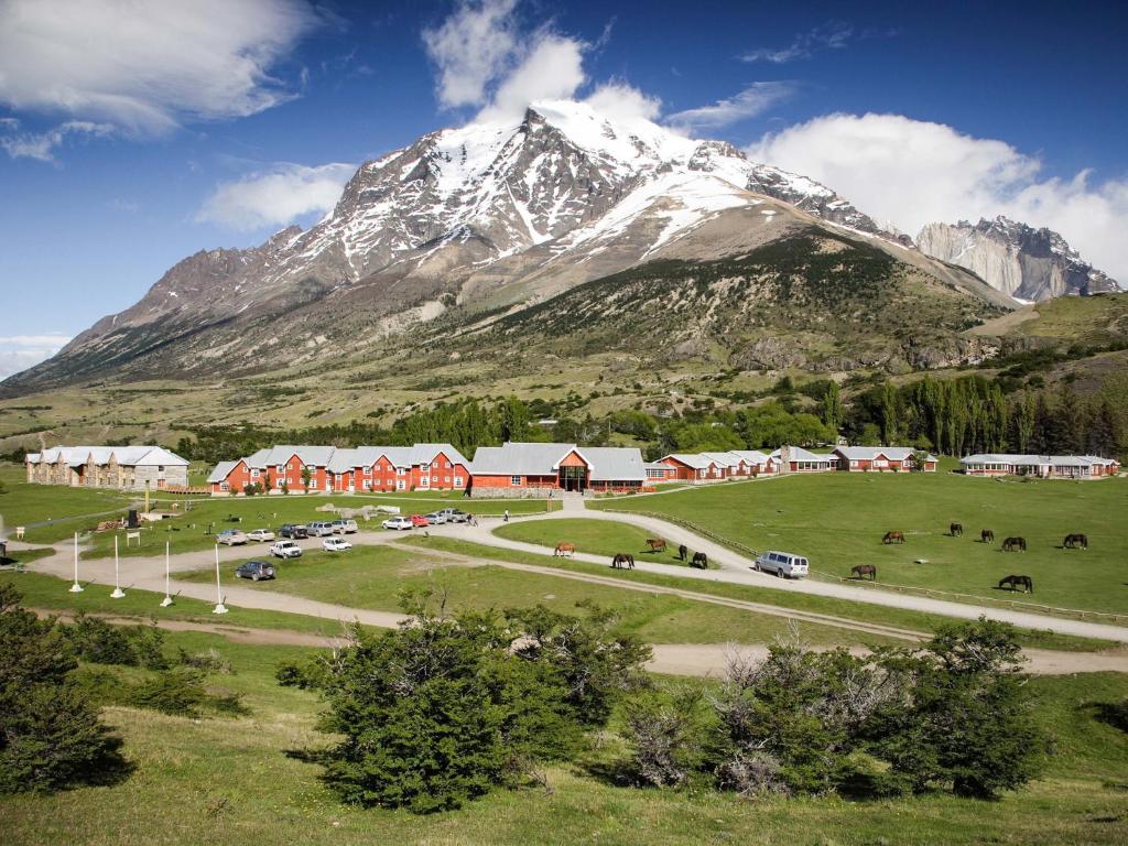 a mountain in the background of a town with a mountain at Hotel Las Torres Patagonia in Torres del Paine