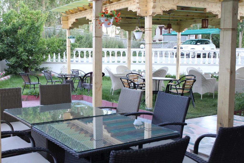 a glass table and chairs under a gazebo at Raku Guest house in Leh