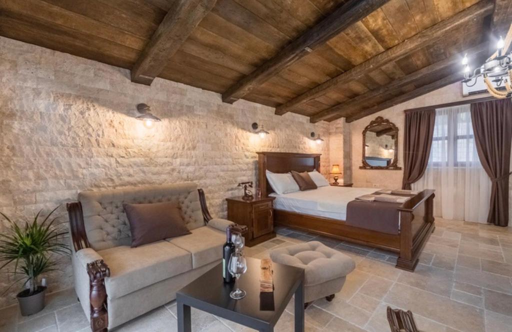 una camera con letto e divano di OLIVE QUEEN Rustic Apartment 1 a Bar