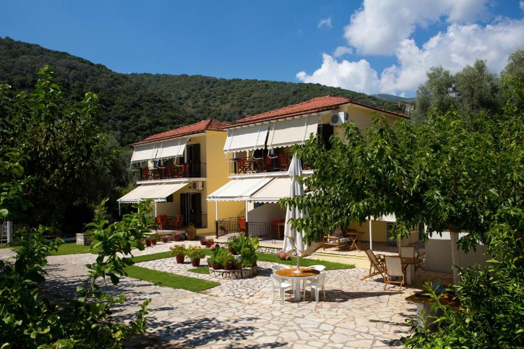 a building with a courtyard with chairs and trees at Natasa Studios in Mikros Gialos