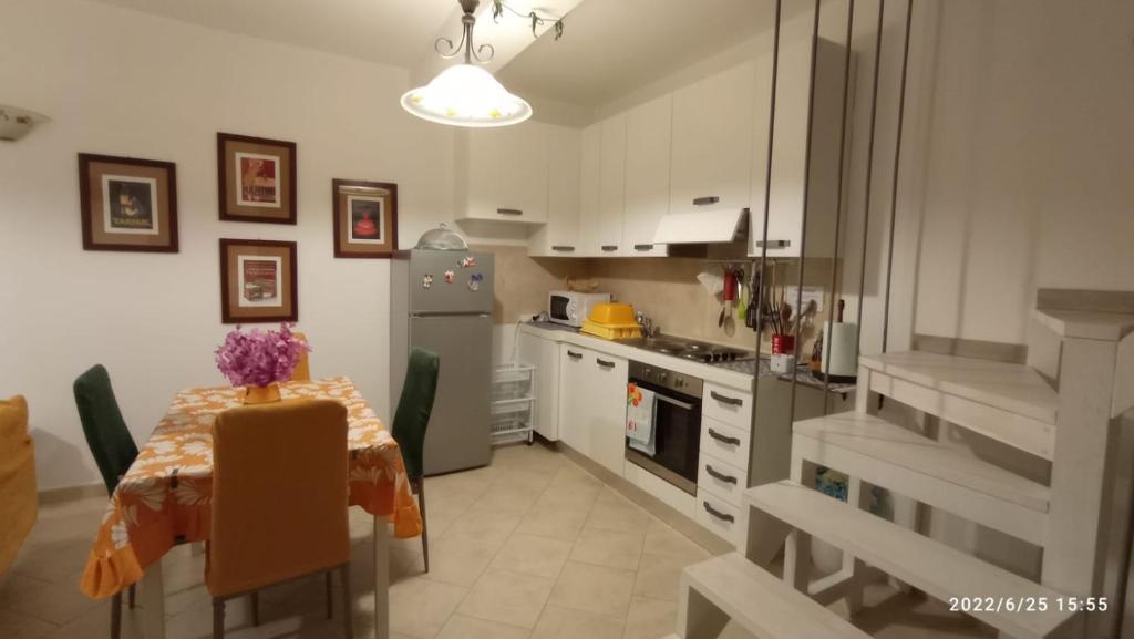 una cucina con tavolo e frigorifero di Casa Matrea Appartamento con box privato a Santa Teresa di Gallura