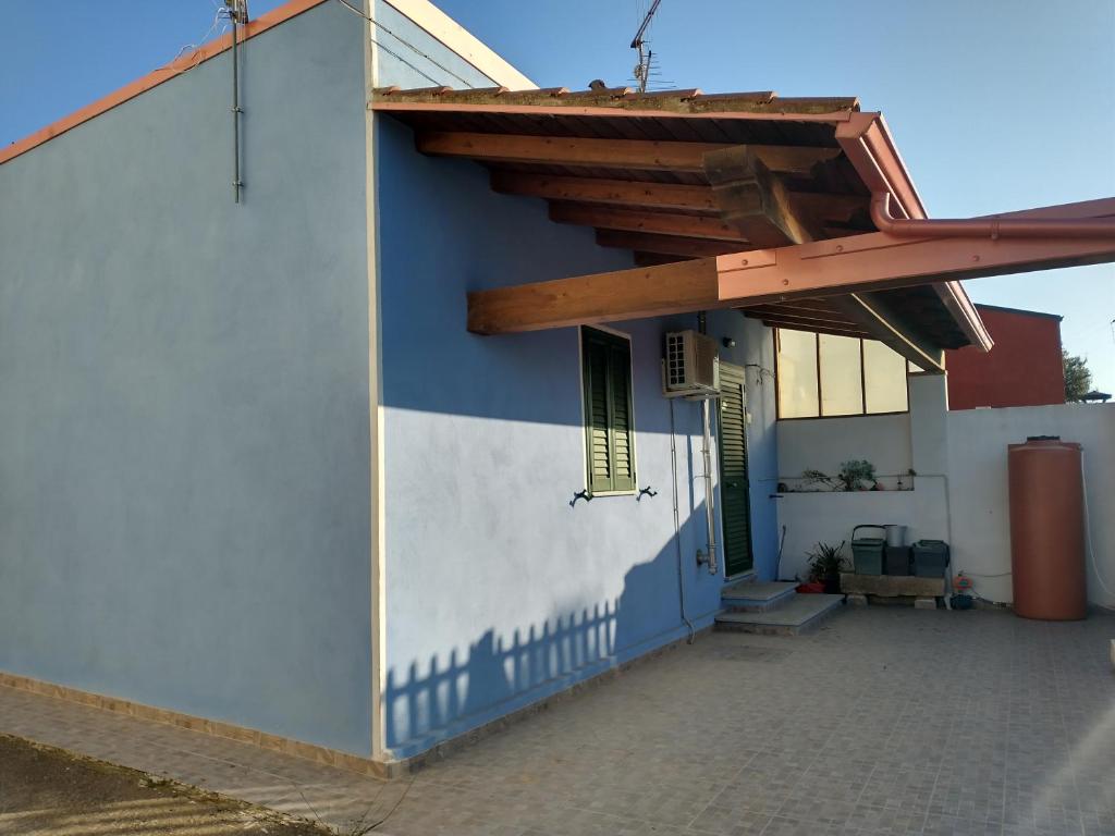 een blauw-wit gebouw met een houten dak bij Da Carla in Iglesias
