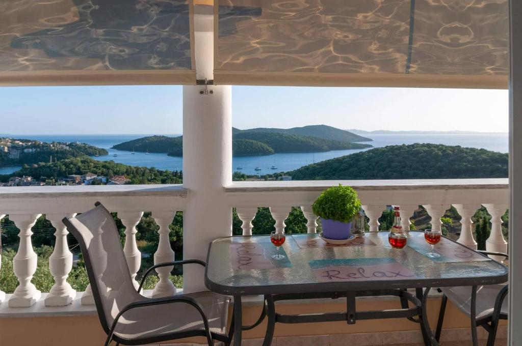 a table and chairs on a balcony with a view at Charoula's Apartments in Syvota