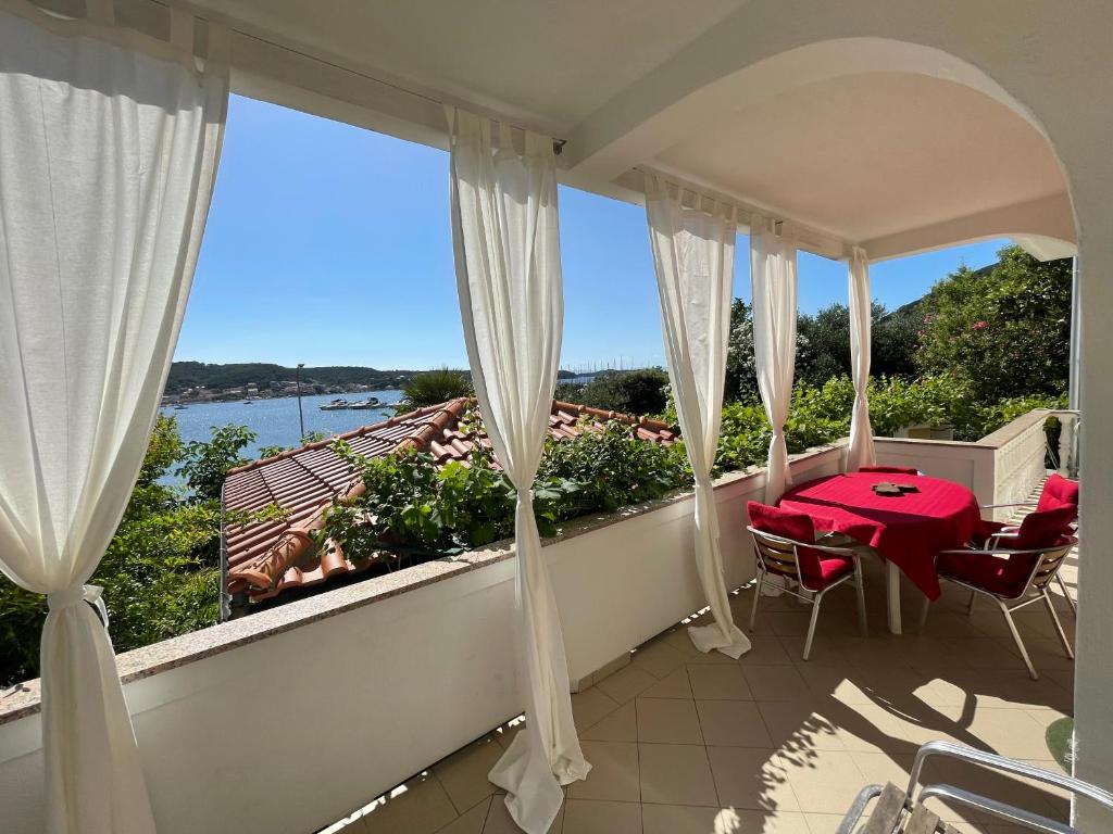 a balcony with a table and a view of the water at Apartments Anica in Rab
